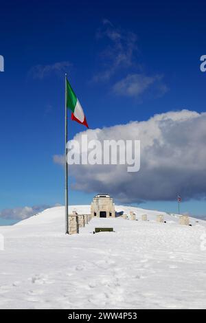 Pieve, TV, Italia - 13 marzo 2024: Memoriale militare con neve e bandiera italiana Foto Stock