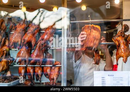 Anatre arrosto appese all'interno di una finestra di un ristorante cinese a Bellevue, Parigi. Foto Stock