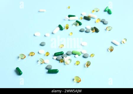 Capsule di olio di pesce e pillole diverse su sfondo blu Foto Stock