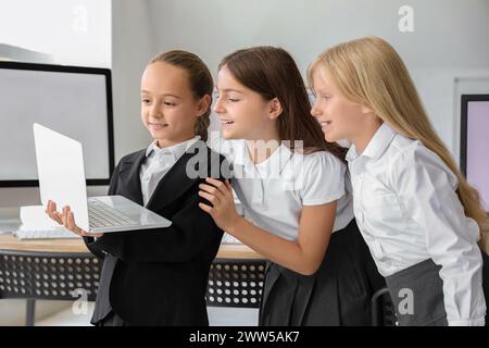 Bambine con un portatile al laboratorio di computer della scuola Foto Stock