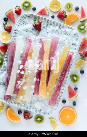 Le freezie fatte in casa si trovano su un vassoio di ghiaccio circondato da frutta fresca. Foto Stock