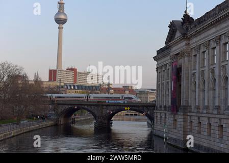 Treno interurbano ad alta velocità Deutsche Bahn ICE che attraversa il ponte ferroviario Hackescher Markt, torre televisiva sullo sfondo, Berlino, marzo 2024 Foto Stock