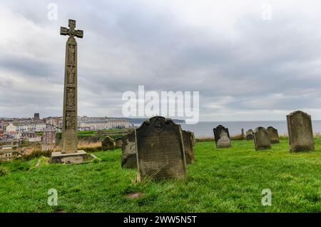 Questa suggestiva fotografia cattura lo storico cimitero della St. Mary's Church a Whitby, Inghilterra, affacciato sul Mare del Nord. Le vecchie lapidi... Foto Stock
