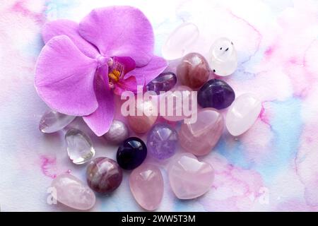 Cristalli di ametista, quarzo rosa e fiore di orchidea. Cristalli curativi, la magia delle pietre preziose. Foto Stock