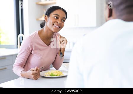 Una giovane coppia afroamericana si gode una colazione insieme a casa in cucina Foto Stock