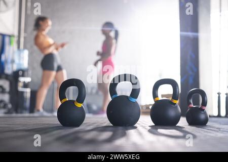 I kettlebell ti attendono con spazio per le copie, mentre un allenatore caucasico istruisce il suo apprendista Foto Stock