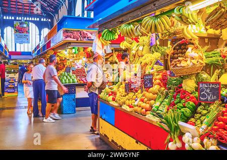 MALAGA, SPAGNA - 28 SETTEMBRE 2019: Mazzi di banane, ananas, mango, pomodori, uva e altre frutta e verdura fresche in una bancarella di Atarazanas cent Foto Stock