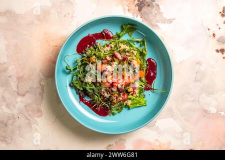 Insalata con zucca, lattuga, pomodori e quinoa. Cospargere con salsa di barbabietole e decorare con le erbe. Isolato su sfondo bianco. Foto Stock