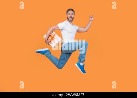 Uomo energico che corre veloce con la confezione regalo. Corriere regalo a mezz'aria. Consegna di regali e regali Foto Stock