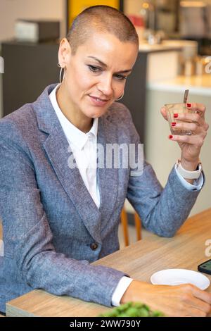 Verticale verticale Vista laterale donna elegante che beve caffè in caffetteria Foto Stock