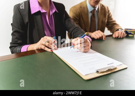 Due professionisti - impegnati nella firma di un contratto, concentrati sulle mani e sui documenti - esecuzione di accordi legali o completamento di documenti ufficiali - Foto Stock