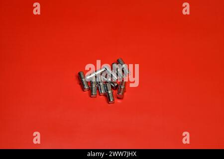 Accessori per armadi. Un gruppo di supporti per ripiani metallici su sfondo rosso. Foto Stock