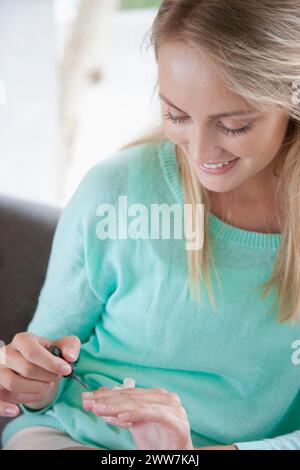 Giovane donna l'applicazione di smalto per unghie Foto Stock