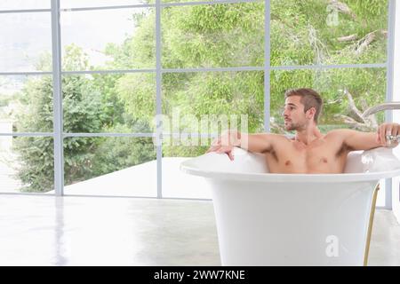 Uomo che si rilassa nella vasca da bagno Foto Stock