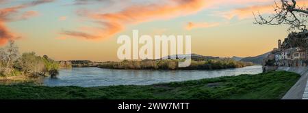 Vista del fiume Ebro e la città vecchia di Miravet, Spagna, evidenziando il castello dei templari nella parte superiore della collina Foto Stock