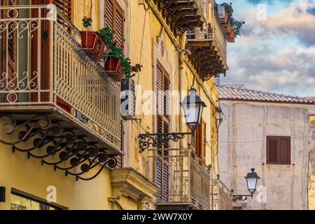 Case dall'architettura tradizionale di Agrigento con balconi in ferro, lanterne e facciata decaduta in Sicilia, Italia. Foto Stock