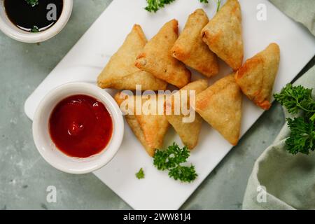 Mini cocktail samosa fatti in casa | antipasto indiano servito con ketchup e salsa tamarinda Foto Stock
