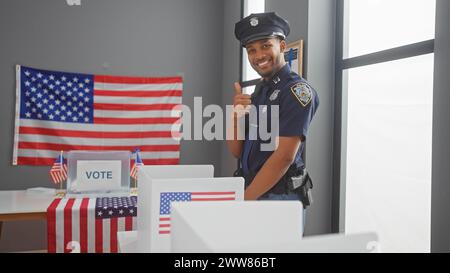 Agente di polizia afroamericano che rinuncia i pollici in un centro elettorale degli Stati Uniti con bandiere americane Foto Stock