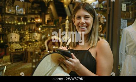 Donna bruna sorridente che si diverte a fare shopping in un suk tradizionale a dubai, emirati arabi uniti. Foto Stock