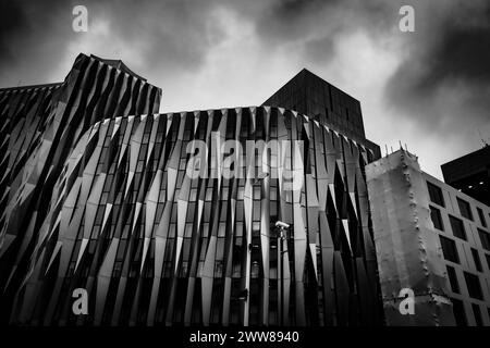 Un quadro bianco e nero degli edifici del centro di Londra, Regno Unito, nuvole scure, finestre in vetro, cemento d'acciaio Foto Stock