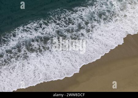 vista dall'alto dell'onda che si infrangono sulla spiaggia sabbiosa con oceano turchese Foto Stock