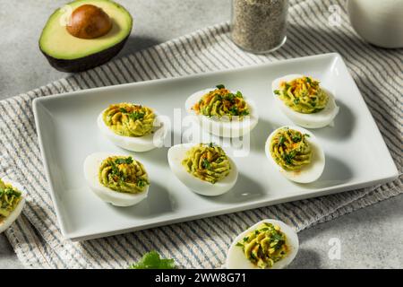 Avocado verde fatto in casa uova spacciate con paprica e coriandolo Foto Stock