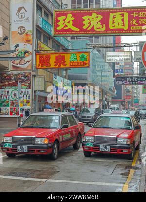 Hong Kong, Cina - 25 aprile 2017: Due veicoli Toyota Red taxi in Street Rainy Day a Kowloon City. Foto Stock