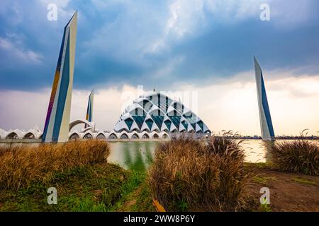Bandung, Indonesia - 4 novembre 2023: Grande Moschea al Jabbar al tramonto (ora d'oro) con lampade e riflessi nello stagno Foto Stock