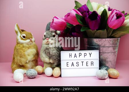 Scatola luminosa di buona Pasqua con decorazione degli elementi pasquali su sfondo rosa Foto Stock