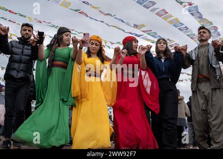 Le donne che indossano abiti tradizionali si vedono ballare durante l'evento. Migliaia di persone si riunirono a Diyarbakir e celebrarono Newroz, che è considerata l'arrivo della primavera e il nuovo anno del calendario persiano. Hanno riempito Newroz Park con bandiere verdi, rosse e gialle e si sono divertiti a cantare canzoni curde. Foto Stock