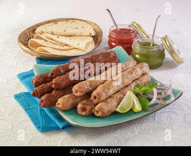 Il Seekh Kabab è una famosa cucina asiatica, preparata con pollo macinato o Mutton o manzo e cucinata con charcoals, poi servita con chutney verde, insalata e pane. Foto Stock