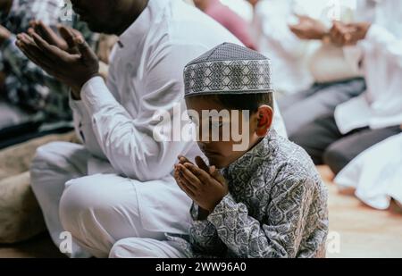 Guwahati, Assam, India. 22 marzo 2024. I devoti musulmani offrono le preghiere del venerdì durante il mese santo del Ramadan in una moschea, il 22 marzo 2024 a Guwahati, Assam, India. Le preghiere del venerdì, note anche come Salat al-Jumu'ah, sono una preghiera congregazionale (Salat) che i musulmani tengono ogni venerdì, poco dopo mezzogiorno invece della preghiera Zuhr. Crediti: David Talukdar/Alamy Live News Foto Stock