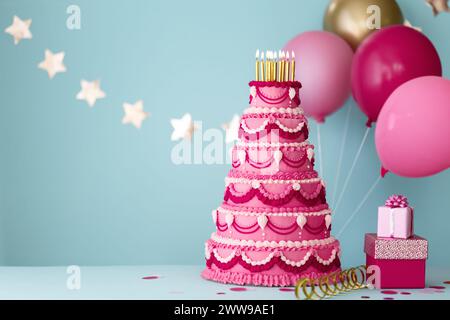 Elaborata torta di compleanno rosa a più livelli con regali e palloncini di compleanno per una festa di compleanno Foto Stock