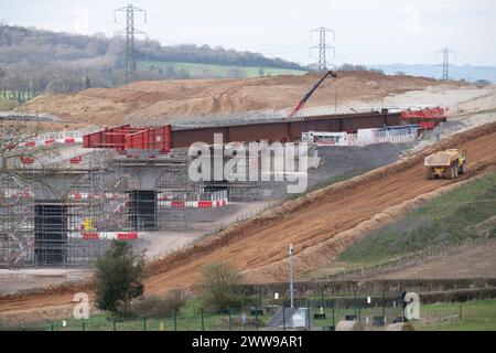 Wendover Dean, Regno Unito. 21 marzo 2024. La HS2 sta costruendo il viadotto Wendover Dean lungo 450 m a Wendover Dean, Buckinghamshire vicino a Great Missenden con 38 travi in acciaio. Il viadotto di mezzo chilometro sarà il primo grande ponte ferroviario del Regno Unito ad essere costruito con una struttura "a doppio composito". Le opere HS2 hanno significato la distruzione di un grande pezzo di antico bosco nella vicina Jones Hill Wood. Anche i terreni agricoli sono stati oggetto di acquisti obbligatori per i quali alcuni locatari non hanno ancora ricevuto alcuna compensazione da HS2. Crediti: Maureen McLean/Alamy Live News Foto Stock