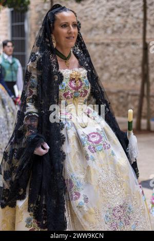 Una donna in abbigliamento tradizionale celebra il Fallas Festival di Gandia, il suo abito è un vibrante omaggio al patrimonio culturale. Foto Stock