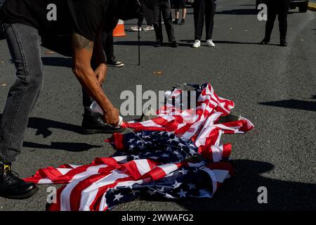 San Juan, Stati Uniti. 22 marzo 2024. I manifestanti versano liquidi più leggeri sulle bandiere americane durante una dimostrazione per protestare contro la visita del vicepresidente Kamala Harris a Porto Rico a San Juan, Porto Rico, venerdì 22 marzo 2024. (Foto di Carlos Berríos Polanco/Sipa USA) credito: SIPA USA/Alamy Live News Foto Stock