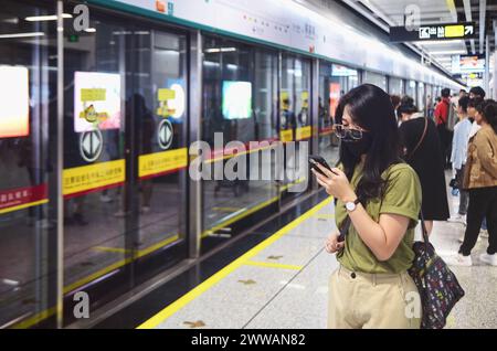 Ragazza che aspetta il treno della metropolitana alla stazione Chen Clan Academy, città di Guangzhou Foto Stock