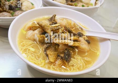 Una ciotola di spaghetti Wonton con condimento di pesce fritto Foto Stock