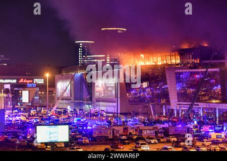 Pechino, Russia. 22 marzo 2024. Il fumo del fuoco sale sopra la sala concerti Crocus City Hall in fiamme a seguito di una sparatoria nel nord-ovest di Mosca, in Russia, il 22 marzo 2024. Secondo il Comitato investigativo della Russia (ICR), più di 60 persone sono state uccise nell'attentato terroristico di venerdì al municipio di Crocus a Mosca. Crediti: Cao Yang/Xinhua/Alamy Live News Foto Stock