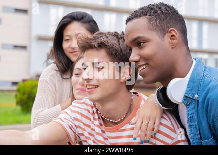 Gruppo multirazziale di studenti amici che ridono mentre scattano un selfie Foto Stock