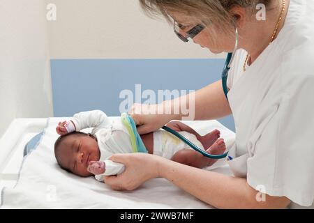 Il pediatra controlla la frequenza cardiaca del neonato. Foto Stock