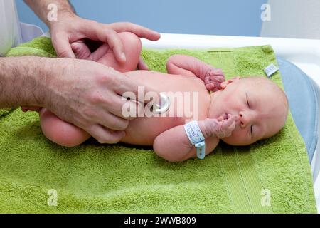 Il pediatra controlla la frequenza cardiaca del neonato. Foto Stock