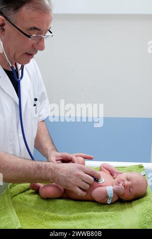 Il pediatra controlla la frequenza cardiaca del neonato. Foto Stock