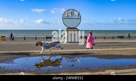 Brighton Regno Unito 23 marzo 2024 - Un cane passa davanti alla scultura Flight of the Langoustine su Hove Plinth sul lungomare in una mattinata soleggiata ma fredda lungo la costa meridionale . La scultura è stata creata dallo scultore di Brighton Pierre Diamantopoulo ed è la seconda ad adornare Hove Plinth : Credit Simon Dack / Alamy Live News Foto Stock