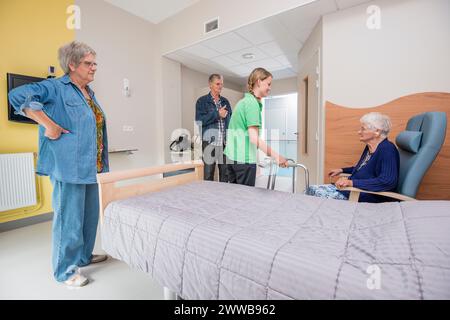 EHPAD - installazione di una nuova residente con problemi di udito accompagnata dalla sua famiglia e da un'infermiera sorda, nella sua stanza. Foto Stock