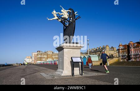Brighton Regno Unito 23 marzo 2024 - i corridori passano accanto alla scultura Flight of the Langoustine su Hove Plinth sul lungomare in una mattinata soleggiata ma fredda lungo la costa meridionale. La scultura è stata creata dallo scultore di Brighton Pierre Diamantopoulo ed è la seconda ad abbellire Hove Plinth : accreditamento Simon Dack / Alamy Live News Foto Stock