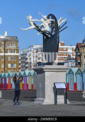 Brighton Regno Unito 23 marzo 2024 - Un corridore si ferma per fotografare la scultura Flight of the Langoustine su Hove Plinth sul lungomare in una mattinata soleggiata ma fredda lungo la costa meridionale . La scultura è stata creata dallo scultore di Brighton Pierre Diamantopoulo ed è la seconda ad adornare Hove Plinth : Credit Simon Dack / Alamy Live News Foto Stock