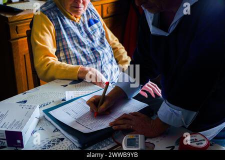 Infermiera freelance durante la sua visita quotidiana ad una persona anziana. Follow-up medici. Foto Stock