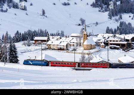 Berguen, Svizzera - 10 gennaio 2024: Treno ferroviario Retico per passeggeri sulla linea Albula nelle Alpi svizzere a Berguen, Svizzera. Foto Stock