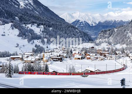 Berguen, Svizzera - 10 gennaio 2024: Treno ferroviario Retico per passeggeri sulla linea Albula nelle Alpi svizzere a Berguen, Svizzera. Foto Stock